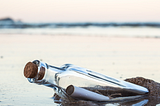 message-in-a-bottle lying in the sand on a beach