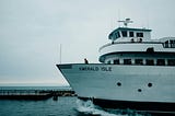 White ferry docking in small port