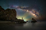 Someone stands against the background of the cosmos at night