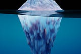 A luminescent iceberg sits in bright blue water in front of a pitch black sky. The iceberg is scattered with hues of lavender and pastel pinks.