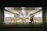 People Walking on the Sidewalk Near a Store with Glass Facad