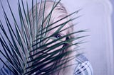 A girl hiding behind a large spikey plant