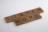“Listen More” spelled out in Scrabble tiles.