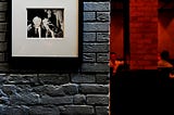 Some framed photographs on a brick wall