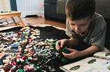 A child is creating something using lego blocks