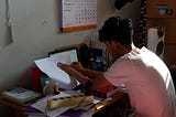 man working at a crowded desk