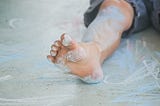 A boy’s foot smudged in colored chalk