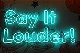 Neon sign that says “Say it louder!”