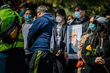 Masked protesters carry an image of Vichar Ratanapakdee, a Thai immigrant killed in an unprovoked attack by a 19-year-old man in San Francisco on January 28, 2021