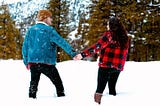 A couple holding hands in the snow.