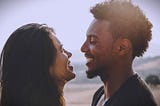 A couple happily smiling at each other.