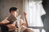 Image of young lady holding a book and a pen