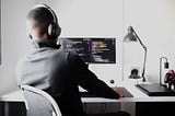 Male coding at desk