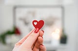 a person holding a tiny valentine heart