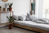 Stylish home interior with comfortable bed and bed plants