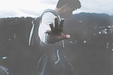 The blurry silhouette of a man who shows his hand to the forefront, as if to say ‘stay away from me’