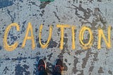 “Caution” written on the sidewalk
