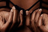 two hands undoing a bra clasp.