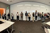 a panorama photo of the SF Digital and Data Services team standing in a line from first hired to newest hires, some members holding up signs marking events like the pandemic