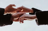 2 pair of hands holding each other