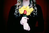 A lady in black holds a bunch of flowers.