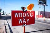 Close up photo of a road sign that says: Wrong way