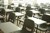 An empty school classroom with rows upon rows of empty desks