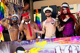 Four gay men looking watching a PRIDE event