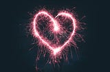 A heart made by fireworks in a black sky