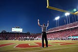 Football referee holding his hands up indicating a successful field goal