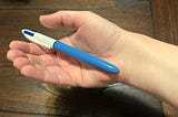 An open hand holds a pen in its palm.