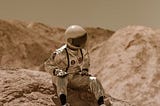 an astronaut doll wearing sneakers, seated on a barren alien landscape