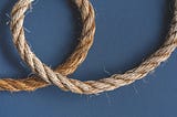 A length of hemp rope laid out on a blue background, with one section shown as a loop.