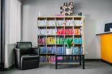 A cupboard full of books and a black sofa