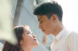 man in white dress shirt looking at a woman in white dress