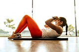 An image of a woman doing crunches as part of exercise