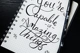 “You’re capable of amazing things” written in bold cursive on a notebook page