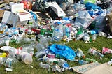 plastic bottles and other plastic waste items overflowing onto the ground.