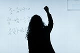 a silhouette of a woman in front of a smart board, working on a math equation