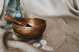 Bronze sound bowl pictured with three clear quarts crystal sitting right next to it.