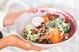 A person holding a plate of food.