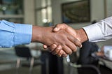 Image of two people shaking hands after a deal. Image of how to get better at sales.