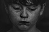 Black and white photo of boy crying. Death. Nobles.