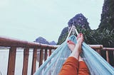 A woman has her feet up in a hammock.