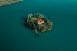 Aerial view of a beautiful private island with a red-roofed estate surrounded by deep blue water, symbolizing isolation, success, and the emotional tension of outgrowing what once felt ideal.