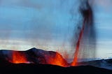 A picture of an active volcano, with red hot flames and spewing ash