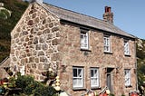 Stone house with white painted windows and chimney