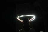 The optical illusion of a halo in laser-light over the head of a silhouetted person