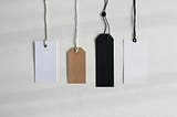 Photo of different sized and  coloured labels hanging down on a white background.
