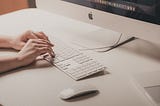 Minimal tech beige-gray aesthetic image of someone typing on a keyboard.